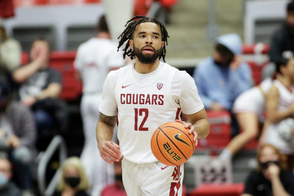 Washington State guard Michael Flowers controls the ball during the second half of an NCAA college basketball game against Washington, Wednesday, Feb. 23, 2022, in Pullman, Wash. (AP Photo/Young Kwak)