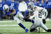 Indianapolis Colts running back Jonathan Taylor (28) is tackled by Las Vegas Raiders defensive end Maxx Crosby (98) and linebacker Divine Deablo (5) during the second half of an NFL football game, Sunday, Jan. 2, 2022, in Indianapolis. (AP Photo/AJ Mast)