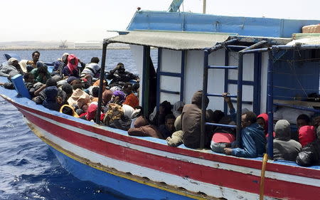 Illegal migrants who attempted to sail to Europe, sit in a boat carrying them back to Libya, after their boat was intercepted at sea by the Libyan coast guard, at Khoms, Libya May 6, 2015. REUTERS/Aymen Elsahli