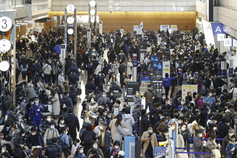 Travelers crowd at a departure lobby of Haneda airport in Tokyo Thursday, Dec. 29, 2022. Japan on Thursday reported a record 420 single-day coronavirus deaths, one day after reaching an earlier record of 425 deaths, according to the Health Ministry. (Kyodo News via AP)