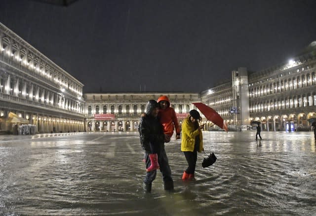 People walk in a flooded St Mark's Square (Luigi Costantini/AP)