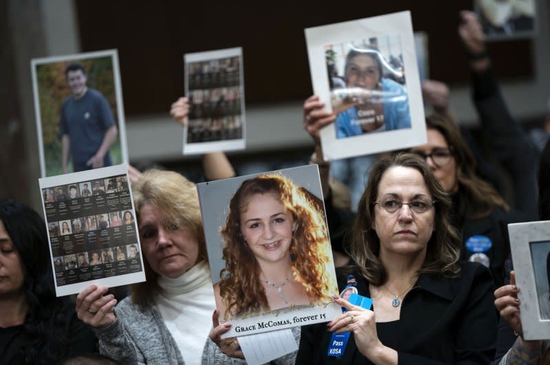 Family members hold photos of their loved ones before a Senate Judiciary Committee hearing in Washington, D.C., on Wednesday. Photo by Bonnie Cash/UPI