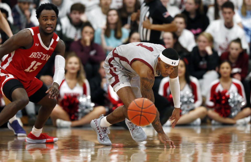 Boston University's Jonas Harper (15) and Colgate's Jordan Burns (1) chase after the ball during the first half of the NCAA Patriot League Conference college basketball championship at Cotterell Court, Wednesday, March 11, 2020, in Hamilton, N.Y. (AP Photo/John Munson)