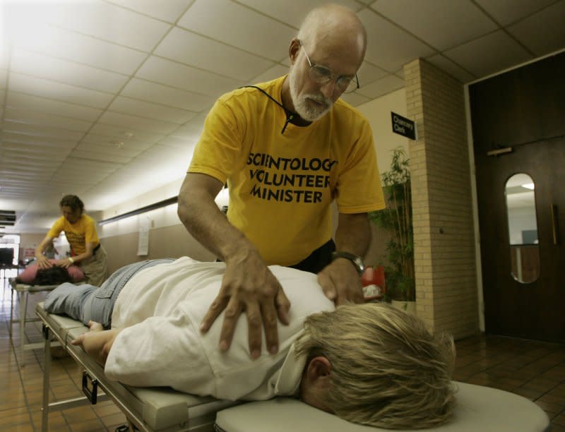 Church of Scientology volunteer minister Richard Royce gives a "nerve assist" to Jackie Arbeiter at the Harrison County Emergency Operations Center in Gulfport, Miss., on September 15, 2005. On February 18, 1954, the Church of Scientology was established in Los Angeles. File Photo by Billy Suratt/UPI