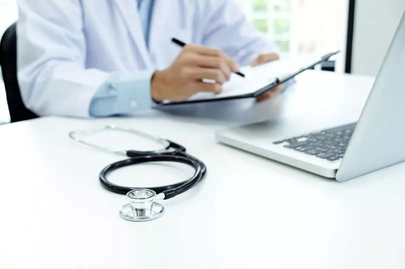 Stock picture of a doctor writing notes at a desk