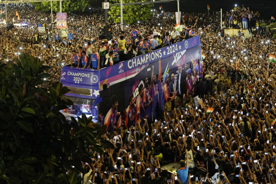 Crowds surround a double-decker bus as the India cricket team takes part in a parade celebrating their T20 Cricket World Cup win, in Mumbai, India, July 4, 2024. (AP Photo/Rajanish Kakade)