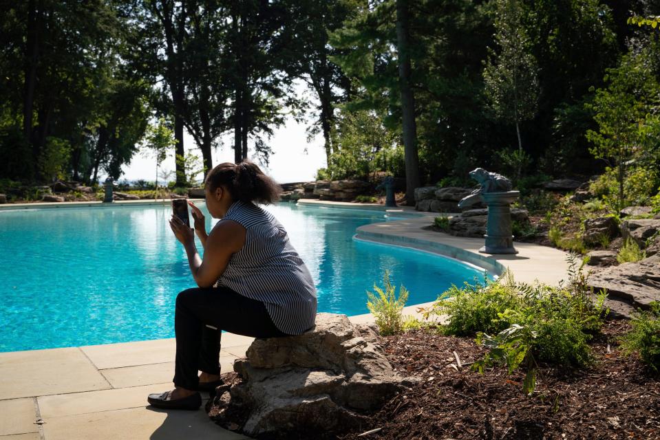 Clinton Township resident Malea Howard, 32, a Ford House employee, livestreams remarks during a pool and lagoon restoration celebration at the Ford House in Grosse Pointe Shores on Monday, August 1, 2022.