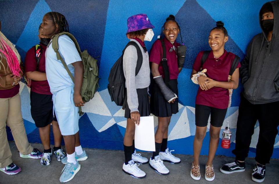 La'Veyah Mosley, 12, middle, shares a laugh with her twin sister La'Niyah and other classmates