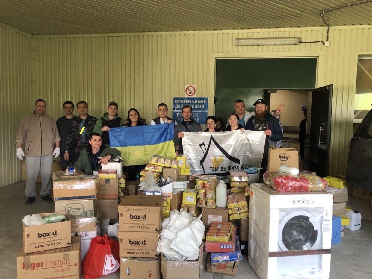 Adelia Sobrenome (centered, above the Ukraine national flag) and Mike Alba (left of her, green sweater) dropped off donations to a hospital in Kharkiv, including the washing machine.