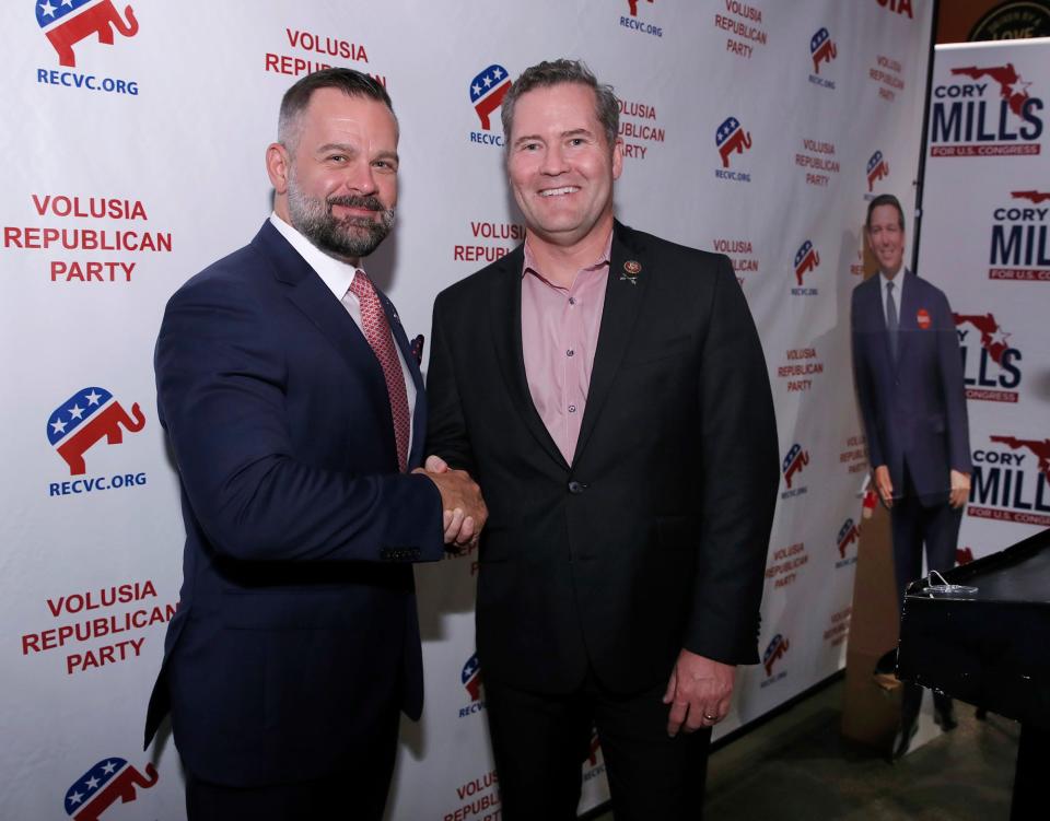 U.S. Reps. Cory Mills and Michael Waltz shake hands during a Republican campaign celebration in November 2022. Both voted no on the motion to remove Rep. Kevin McCarthy from his role as House speaker.