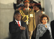 President Cyril Ramaphosa, left, takes the national salute, alongside his wife Tshepo Motsepe, right, on their arrival for the State of the National Address at parliament in Cape Town, South Africa, Thursday June 20, 2019. (AP Photo/ Pool)