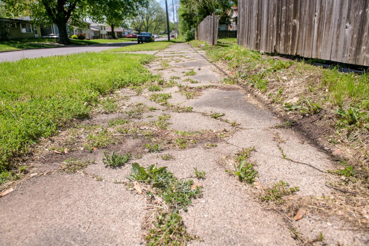 Weeds have taken over a section of crumbling sidewalk along W. Marquette Street in South Peoria.