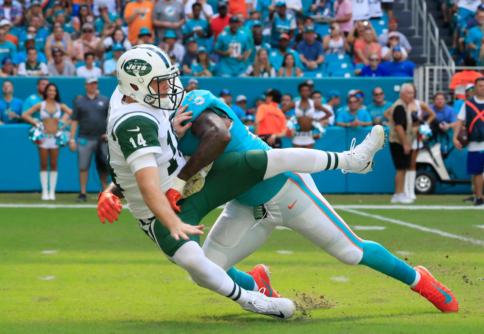 <p>Sam Darnold #14 of the New York Jets is hit by Andre Branch #50 of the Miami Dolphins in the first quarter of their game at Hard Rock Stadium on November 4, 2018 in Miami, Florida. (Photo by Cliff Hawkins/Getty Images) </p>