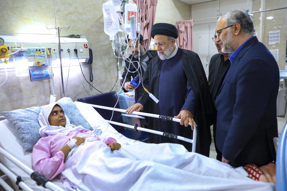 In this photo released by the Iranian Presidency Office, Iranian President Ebrahim Raisi, center, visits a woman who was wounded in Wednesday's bomb explosion in the city of Kerman about 510 miles (820 kms) southeast of the capital Tehran, Iran, Friday, Jan. 5, 2024. Iranian officials tried Friday to link Israel and the U.S. to an Islamic State group-claimed suicide bombing, seeking to intertwine the assault with wider Middle East tensions from the Israel-Hamas war. (Iranian Presidency Office via AP)