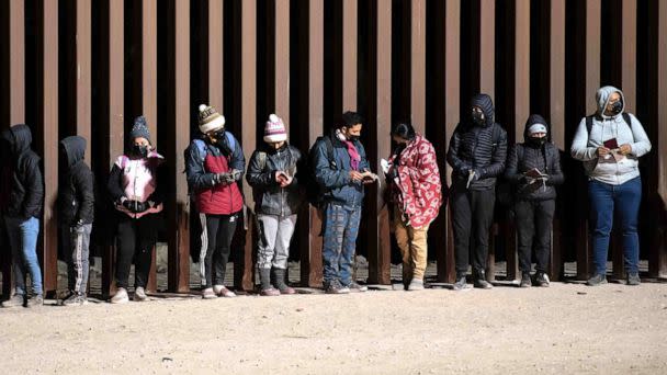 PHOTO: In this Dec. 26, 2022, file photo, asylum-seekers line up to be processed by US Customs and Border Patrol agents at a gap in the US-Mexico border fence near Somerton, Ariz. (Rebecca Noble/AFP via Getty Images, FILE)