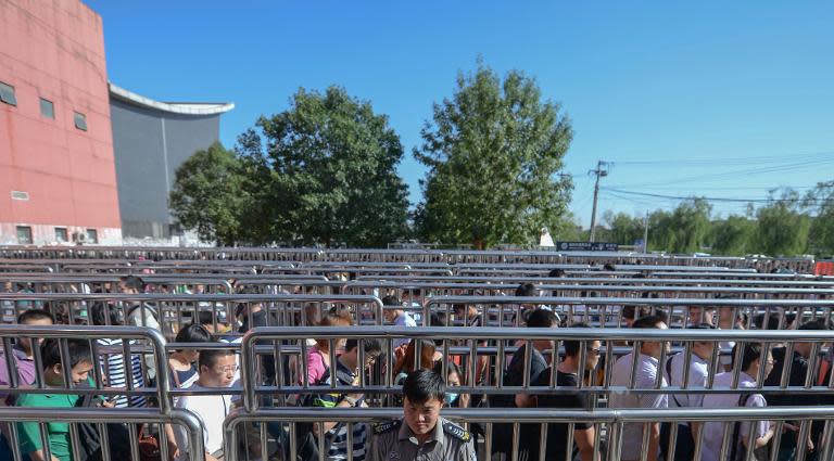 People queue outside a subway station in Beijing on May 26, 2014 to go through a security check