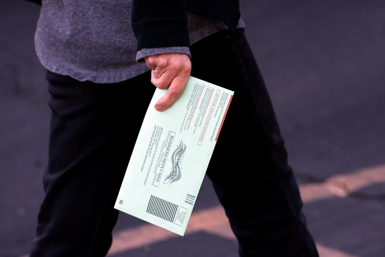 A voter holds a ballot on arriving at the Burton Barr Library voting location on Nov. 8 in Phoenix.