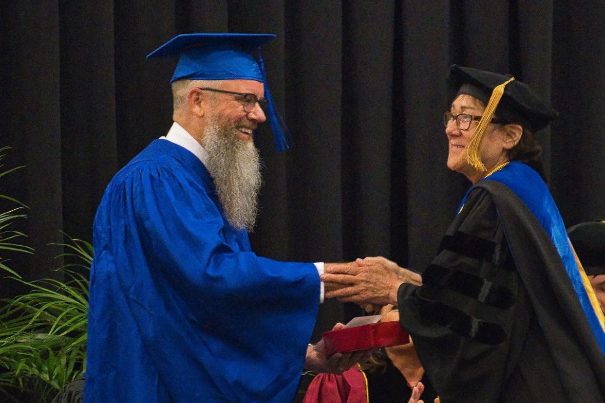 At MCCC’s 57th annual commencement ceremony, Honorary Grand Marshal Dean Kerste is congratulated by Grace Yacke, vice president of instruction.