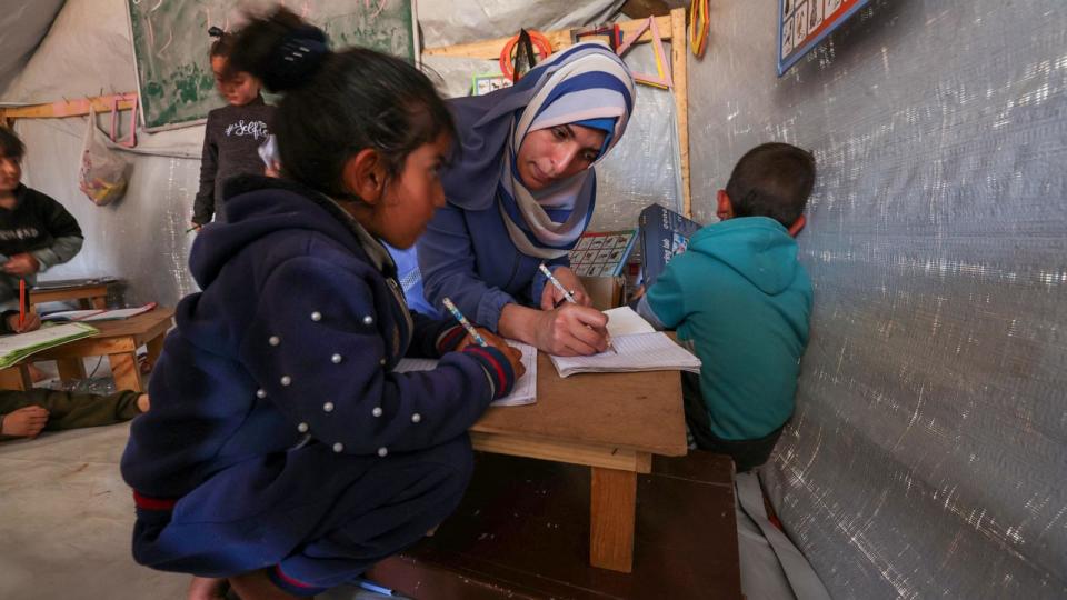 PHOTO: A woman teaches children in a makeshift classroom at a camp for displaced Palestinians in Rafah, in the southern Gaza Strip, Mar. 26, 2024. (Mohammed Abed/AFP via Getty Images)