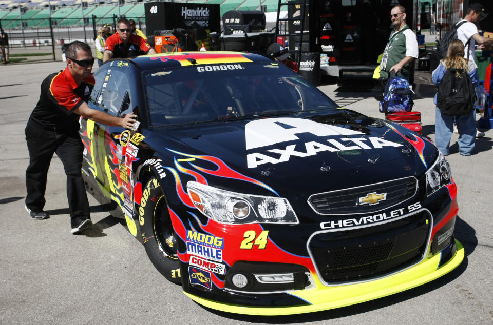 Crew members push the car of Jeff Gordon (24) to his garage Friday, May 9, 2014, at Kansas Speedway in Kansas City, Kan., for Saturday night's NASCAR Sprint Cup series auto race. (AP Photo/Colin E. Braley)