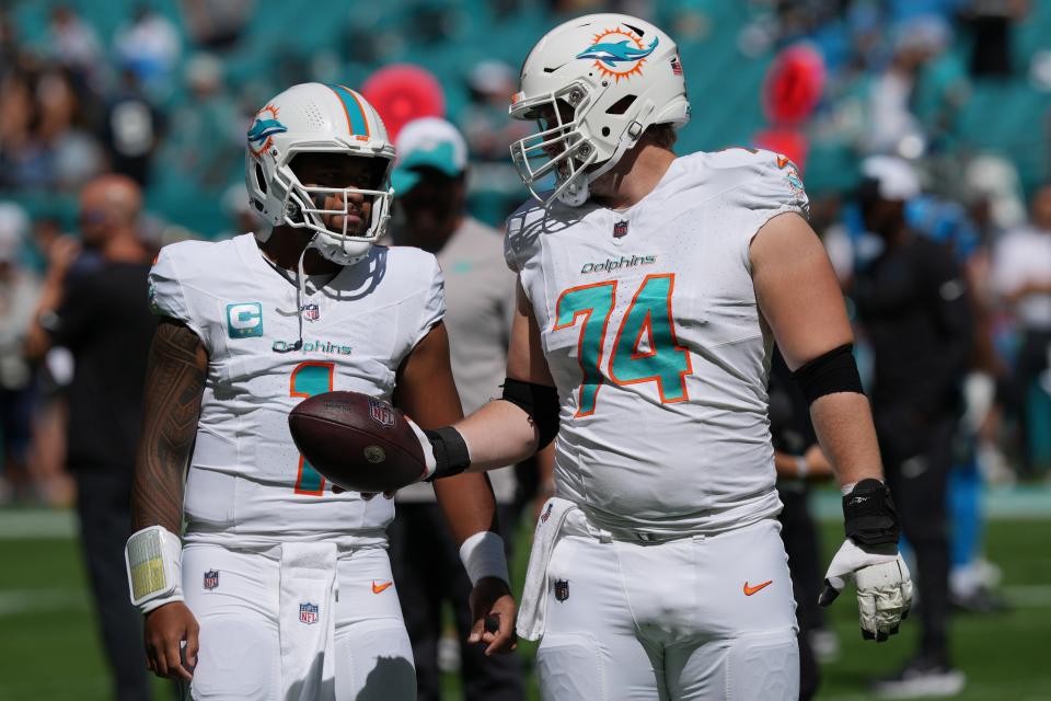 Miami Dolphins offensive tackle Liam Eichenberg (74) talks with quarterback Tua Tagovailoa (1) before the NFL game against the Carolina Panthers at Hard Rock Stadium in Miami Gardens, Oct. 15, 2023.