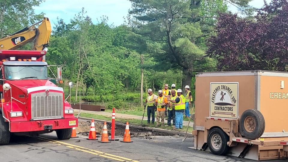 County crews work to repair a severed sewage line and resulting sinkhole on Oradell Avenue in Oradell, New Jersey, Monday, May 23, 2022.