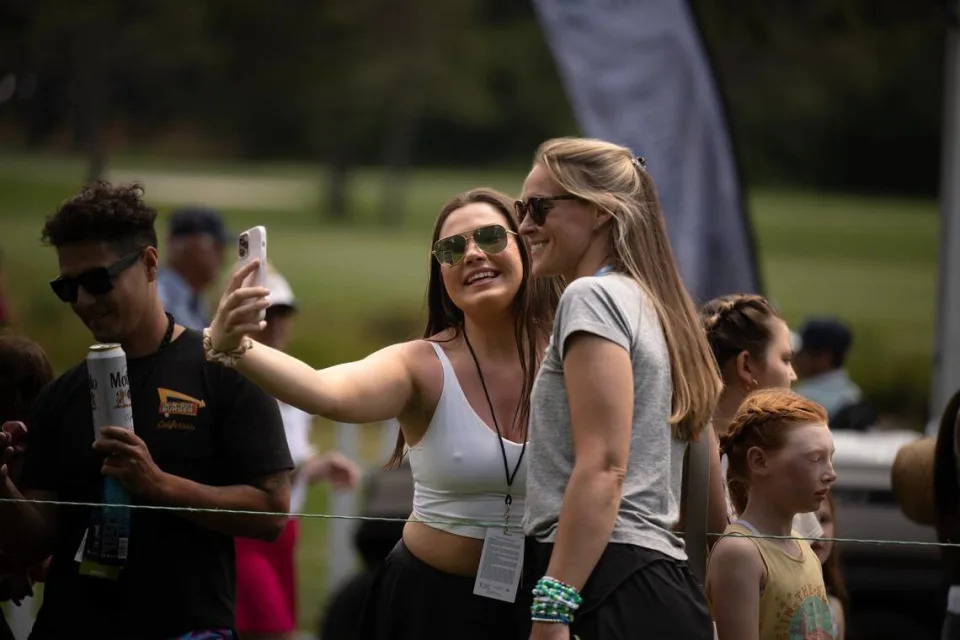 Kylie Kelsey, right, wife of Jason Kelsey, poses for a selfie with a fan in the first round of the American Century celebrity golf championship on Friday, July 12, 2024, in Stateline, Nev.