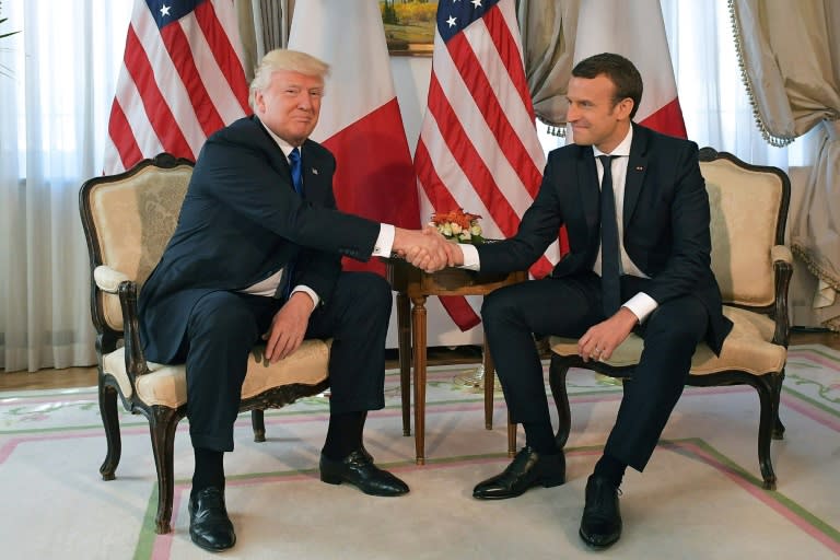 US President Donald Trump locks hands with French President Emmanuel Macron on the sidelines of the first NATO summit for both leaders