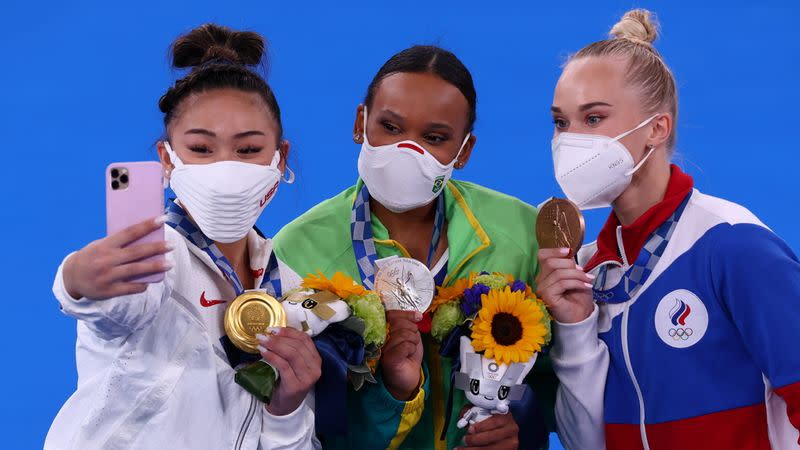 Foto del jueves de la estadounidense Sunisa Lee scándose una foto con la brasileña Rebeca Andrade y la rusa Angelina Melnikova tras la final del all-around en los Juegos de Tokio.