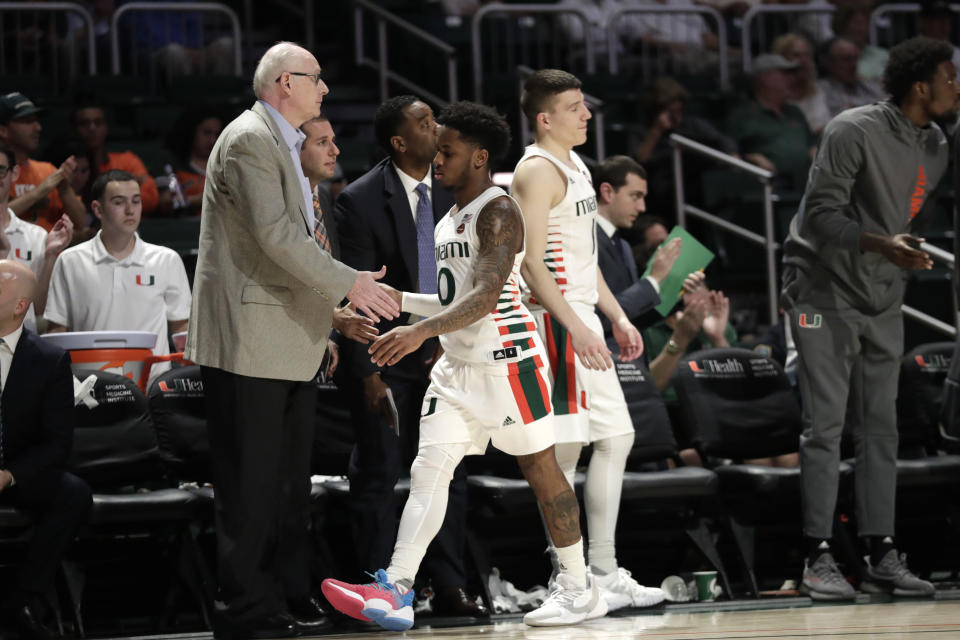 Miami head coach Jim Larranaga, left, shakes hands with guard Chris Lykes (0) during the second half of an NCAA college basketball game against Boston College, Wednesday, Feb. 12, 2020, in Coral Gables, Fla. Miami won 85-58. (AP Photo/Lynne Sladky)