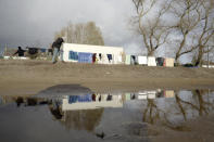 A migrant walks in a makeshift camp outside Calais, northern France, Saturday, Nov. 27, 2021. At the makeshift camps outside Calais, migrants are digging in, waiting for the chance to make a dash across the English Channel despite the news that at least 27 people died this week when their boat sank a few miles from the French coast. (AP Photo/Rafael Yaghobzadeh)