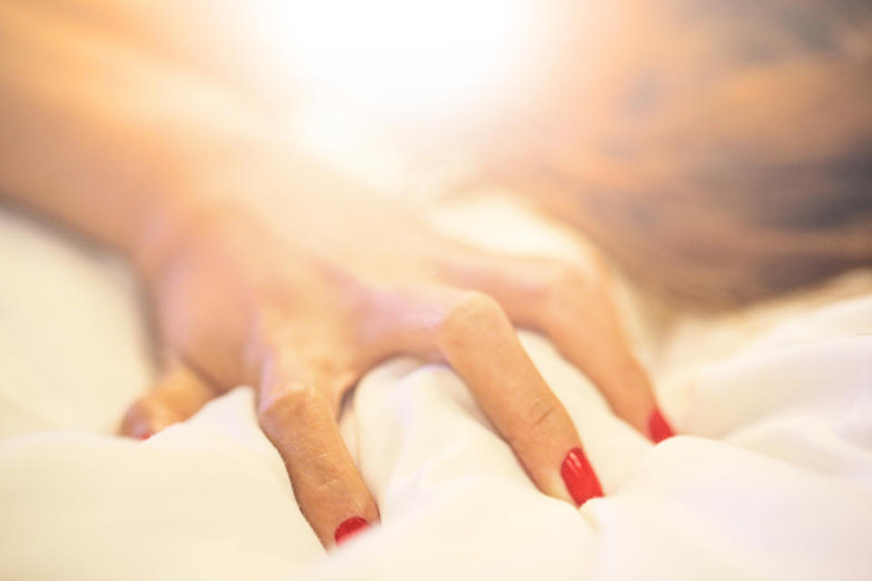 Hand gripping bedsheet (Getty Images)