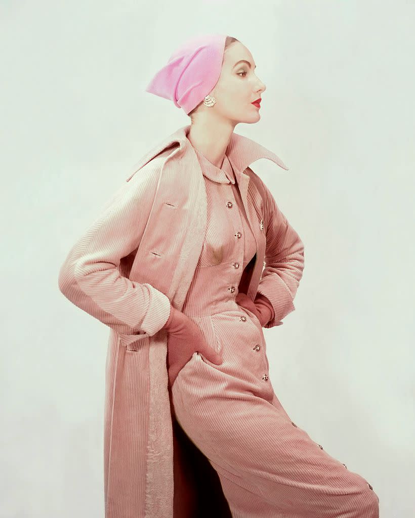 Model in honey-colored Crompton corduroy coat with lining of alpaca and matching sleeveless dress worn with brown knitted cashmere and wool gloves and pink velour cap for Vogue, 1954. (Photo: Vogue/Getty Images)