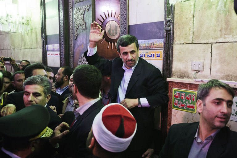 Iranian President Mahmoud Ahmadinejad (C) gestures at the end of an official visit to al-Hussein mosque in Cairo on February 5, 2013. Egypt's top cleric has told visiting Ahmadinejad not to interfere in the affairs of Bahrain or other Gulf states, and to uphold the rights of his country's Sunni minority