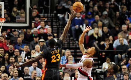 Feb 19, 2016; Portland, OR, USA; Portland Trail Blazers guard Damian Lillard (0) hits a shot over Golden State Warriors forward Draymond Green (23) during the third quarter of the game at the Moda Center at the Rose Quarter. The Blazers won the game 137-105. Mandatory Credit: Steve Dykes-USA TODAY Sports