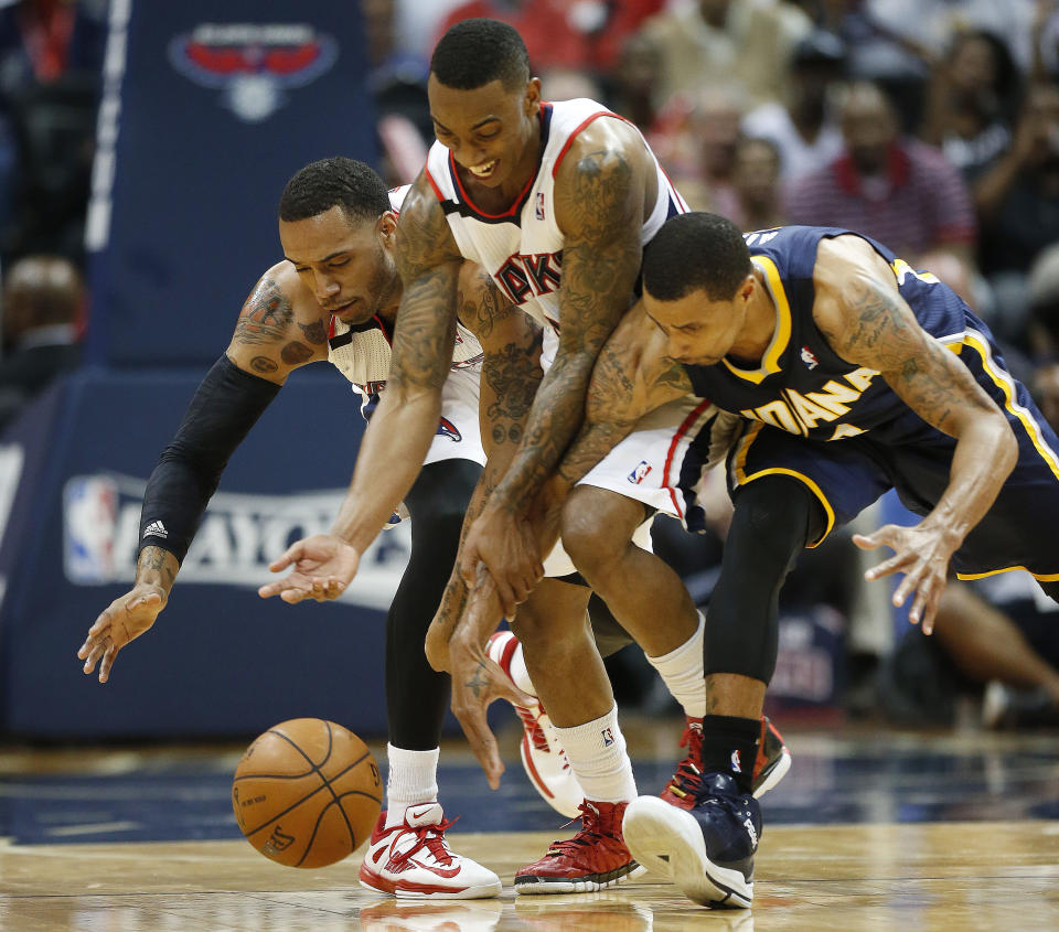 Atlanta Hawks forward Mike Scott, left, and guard Jeff Teague, center, chase a loose ball with Indiana Pacers forward Paul George, right, in the second half of Game 3 of an NBA basketball first-round playoff series on Thursday, April 24, 2014, in Atlanta. The Hawks won 98-85. (AP Photo/John Bazemore)