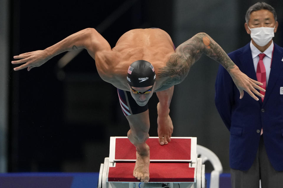 Caeleb Dressel, of the United States, starts the men's 100-meter butterfly final at the 2020 Summer Olympics, Saturday, July 31, 2021, in Tokyo, Japan. (AP Photo/Gregory Bull)