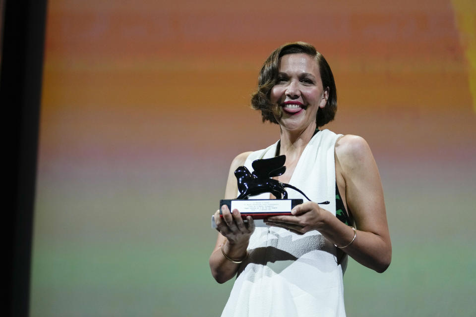 FILE - In this Sept, 11, 2021 file photo Maggie Gyllenhaal holds the Best Screenplay award for 'The Lost Daughter' onstage at the closing ceremony during the 78th edition of the Venice Film Festival in Venice, Italy. (AP Photo/Domenico Stinellis, File)