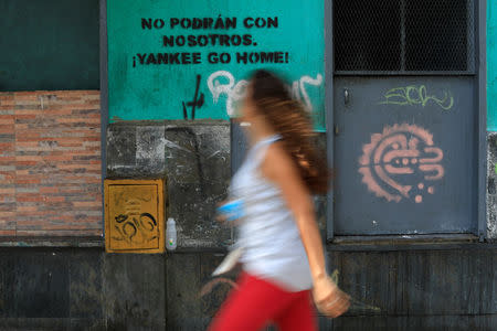 A woman walks past a graffiti that reads: "You will not be able to do it with us. Yankee go home" in downtown Caracas, Venezuela May 21, 2018. REUTERS/Marco Bello