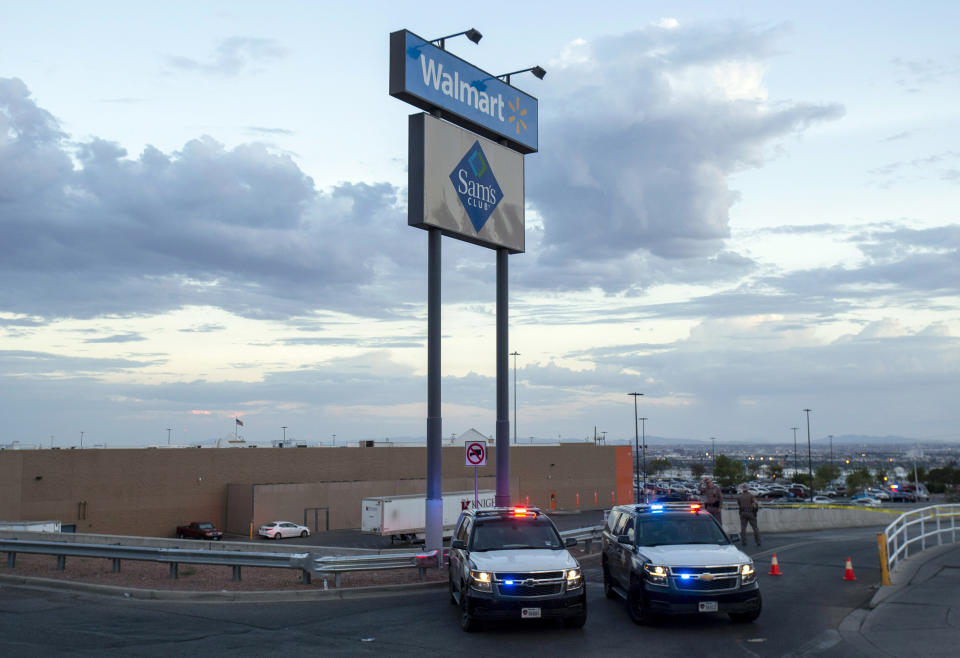 FILE - In this Aug. 3, 2019, file photo, Texas state police cars block access to the Walmart store in the aftermath of a mass shooting in El Paso, Texas. Walmart has quietly hired off-duty officers at dozens of its stores across El Paso, where a gunman opened fire in August at one of the retail giant's locations and killed 22 people. The move comes as Walmart plans Thursday, Nov. 14, to reopen the store where the attack happened amid ongoing lawsuits over safety. (AP Photo/Andres Leighton, File)