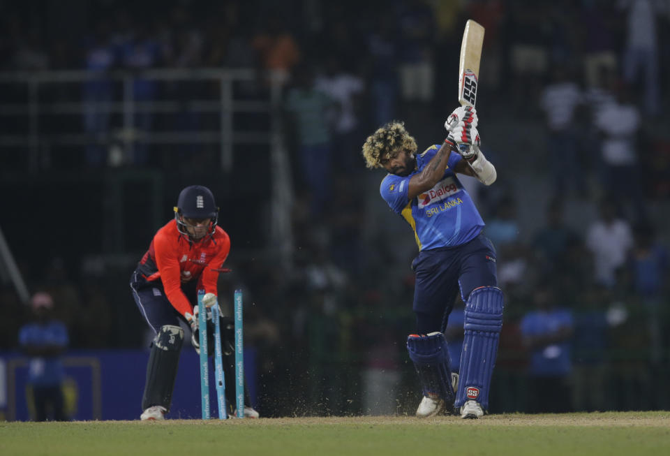 Sri Lanka's Lasith Malinga, right, is bowled out by England's Joe Denly during the Twenty20 international cricket match between Sri Lanka and England in Colombo, Sri Lanka, Saturday, Oct. 27, 2018. (AP Photo/Eranga Jayawardena)