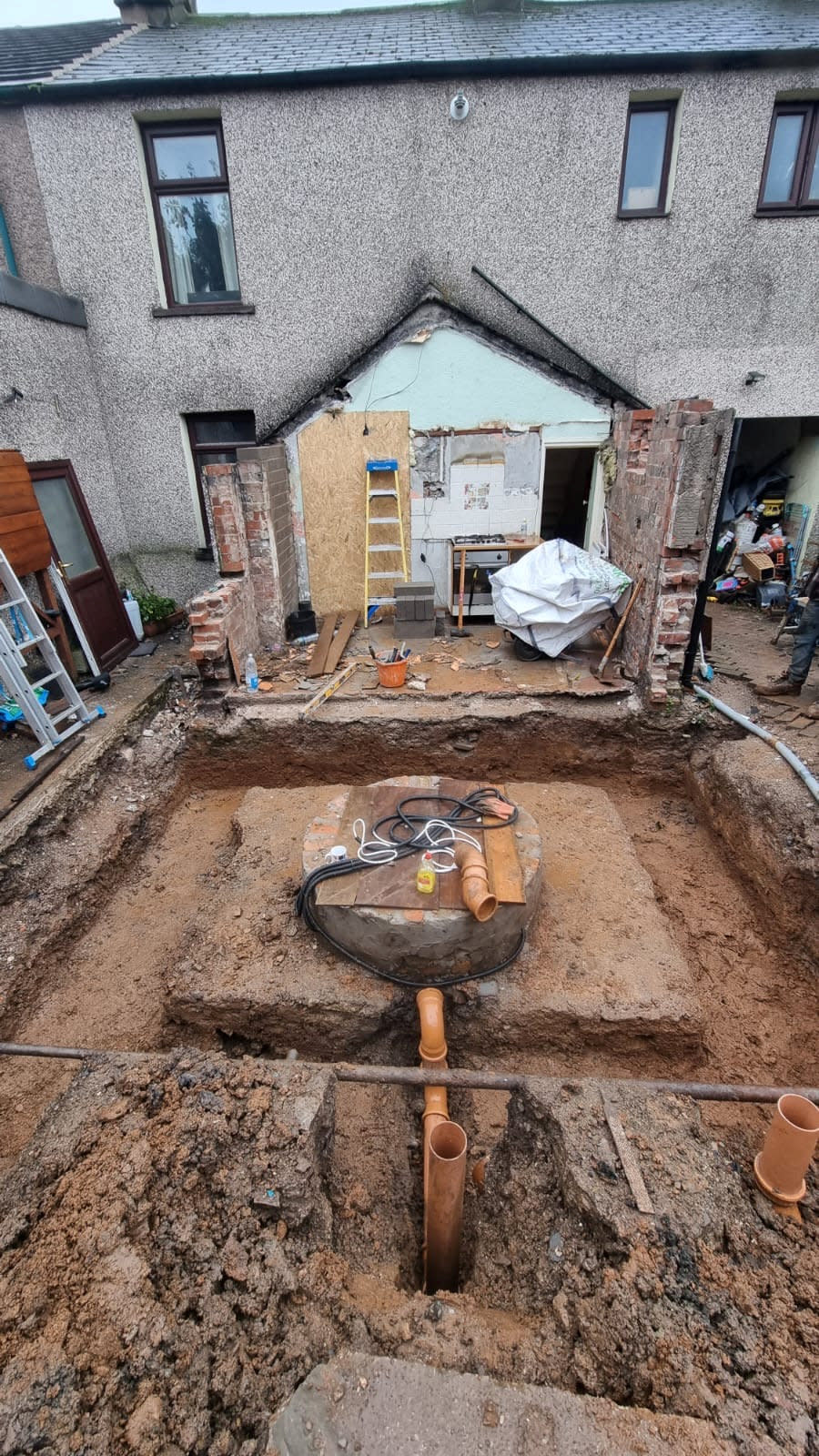 The well at the back of the garden. Photo released March 12 2024. See SWNS story SWLSwell. A family were left stunned after finding a â€˜mysteryâ€™ 22ft well beneath their home during building work to extend their kitchen. Mum Louise Watson, 45, said workmen unearthed the water reservoir below an old lean-to structure, which was attached to their 130-year-old three-bed terrace.The top of the brick-lined well, which was covered by a heavy slate slab, was discovered two feet (60cm) beneath the ground's surface.When the family opened a huge pit, they sent a camera down to inspect it and found it contained 6ft (1.8m) of 