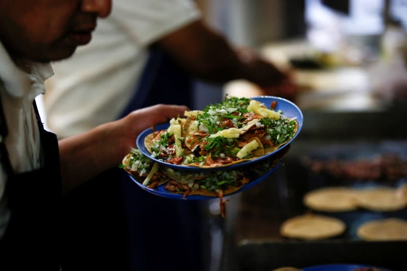 Un hombre es fotografiado con alimentos en un restaurante de Ciudad de México, en momentos en que México se prepara para el impacto del COVID-19, la enfermedad causada por el coronavirus