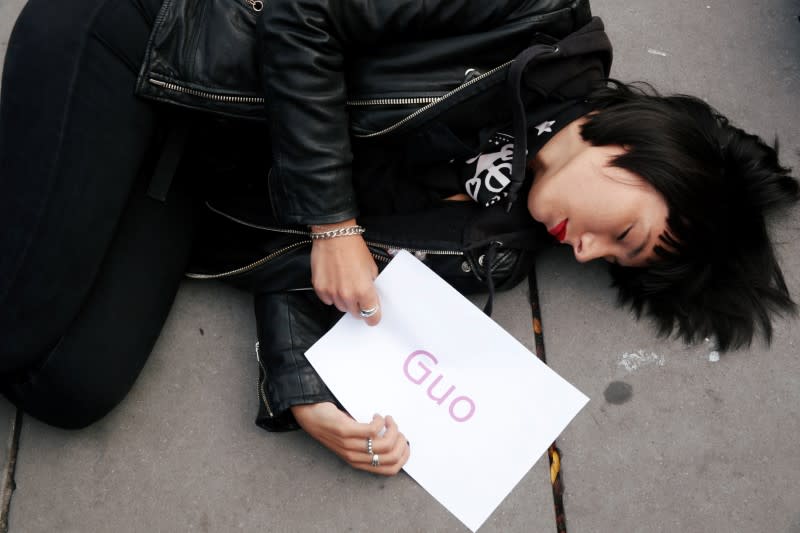 A woman stages a "die-in" at Place de la Republique during a demonstration against femicide and violence against women in Paris
