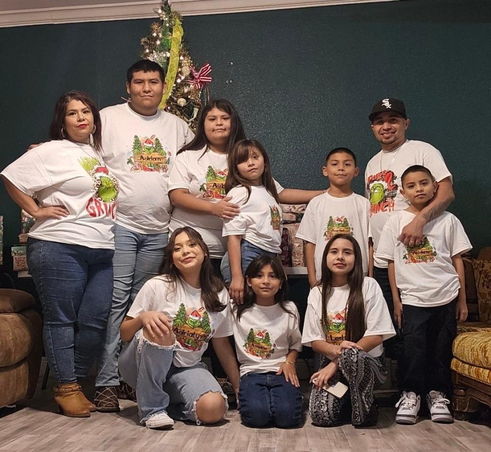 Monique and her family stand in front of a Christmas tree.