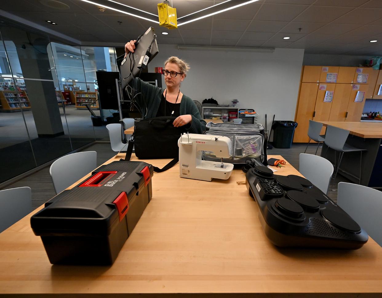 Linnea Sheldon, Worcester Public Library community relations and communications manager, unpacks a laptop and a Wi-Fi hot spot that, along with a bicycle repair kit, a sewing machine and a digital drum set, are part of the Library of Things.