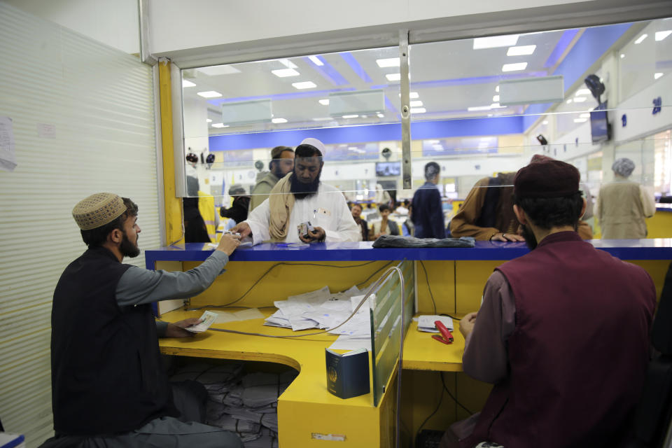 An Afghan man waits to receive his passport at the main post office in the city of Kabul, Afghanistan, Wednesday, July 3, 2024. In parts of Afghanistan where there are no street names or house numbers, utility companies and their customers have adopted a creative approach for connecting. They use mosques as drop points for bills and cash, a "pay and pray" system. (AP Photo/Siddiqullah Alizai)