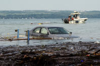 <p>A car is seen floating in Seneca Lake as crews attempt to drag a shed out of the water at Lodi Point in Lodi, N.Y., Wednesday, August 15, 2018, after heavy rain and flash flooding on August 14, 2018, led to evacuations and destruction in the Finger Lakes region. (AP Photo/Heather Ainsworth) </p>