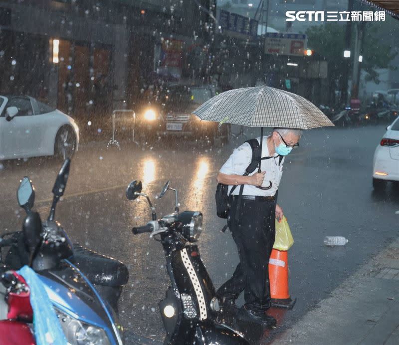 夜間降下豪雨，民眾外出注意交通安全。（圖／記者邱榮吉攝）