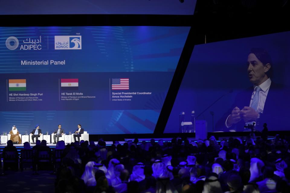 The U.S. Envoy for Energy Affairs Amos Hochstein, right on the screen, talks to the oil and energy minsters at the opening ceremony of the Abu Dhabi International Petroleum Exhibition & Conference in Abu Dhabi, United Arab Emirates, Monday, Oct. 31, 2022. Saudi Arabia and the United Arab Emirates defended on Monday a decision by OPEC and its allies to cut oil production, even as an American envoy warned of "economic uncertainty" ahead for the world. (AP Photo/Kamran Jebreili)